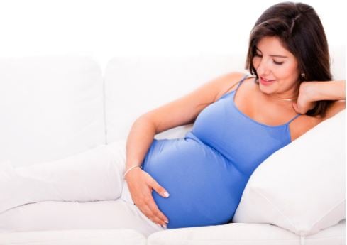 mujer embarazada descanzando en sillon